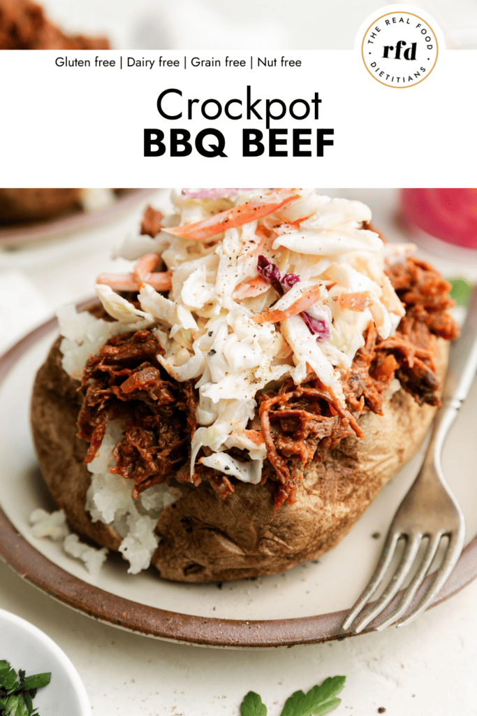 Close up side view baked potato stuffed with shredded BBQ beef topped with coleslaw.