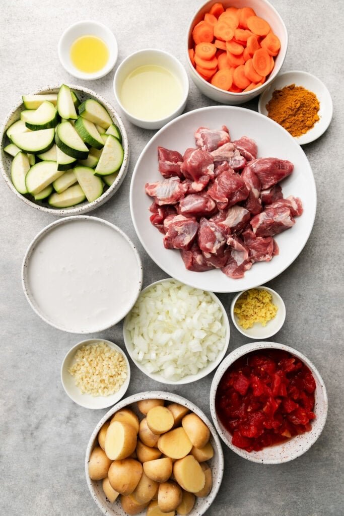 All ingredients for instant pot lamb curry arranged together in small bowls